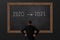 Business 2021 concept, business man look on the black board that change from year 2020 to new year 2021 , copy space