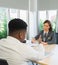 Business airline worker looks serious writing note on table and african businessman negotiate to woman in meeting room. Business