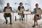 Business colleagues using laptops at desks in office