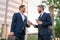 Business communication. Two business men talking on coffee break outdoors. Two diverse businessmen talking together