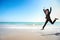 Business competition: businesswoman jumping with hand on the beach, meaning of winner