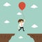 Business concept, businessman flies across a gap to another cliff by using balloon.