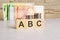 business concept. cubes with the inscription - ABC dollars and monet on grey table