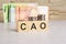 business concept. cubes with the inscription -CAO. euro and monet on grey table