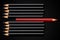 Business concept of disruption, leadership or think different; red pencil in row of black pencils pointing in opposite direction