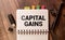 Business concept. On the financial charts lies a pen and a sign with the inscription - capital gain