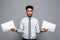 Business Concept - handsome young professional african american businessman holding report papers.