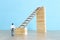 Business concept picture of challenge. A man stands on the edge of a high wall and passes the gap by placing a ladder. Problem