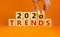 Business concept of planning 2021. Male hand flips wooden cube and change the inscription `TRENDS 2020` to `TRENDS 2021`.