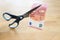 Business concept, ten Euro banknote is cut with scissors, symbol for wage reduction or pay less money in coronavirus crisis,