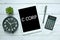 Business concept. Top view of plant,clock,calculator,pen and tablet written with C Corp on white wooden background.