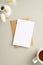 Business concept. Top view vertical photo of paper sheet craft paper envelope cup of tea and vase with white lagurus flowers on