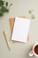 Business concept. Top view vertical photo of paper sheet craft paper envelope gold pen binder clips cup of tea and eucalyptus on