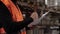 business conctrol concept of male worker in orange vest checking papers in warehouse