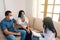 A business consultant with a protective mask advises a young couple with a medical mask