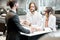 Business couple at the stand with salesperson in the showroom