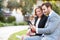 Business Couple Using Digital Tablet On Park Bench