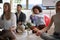 Business coworkers meditating at work, sitting on the floor. Afro-american female making visualization of money income increase.