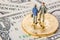 Business deal or agreement and success concept. Two miniature businessmen shaking hands while standing on bitcoin cryptocurrency a