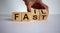 Business and design concept. Man hand flips wooden cubes with words `fail fast` on beautiful white background, copy space