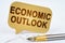 On the business diagram is a pen and a sign with the inscription - economic outlook