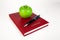 Business diary with pen and green apple