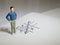 Business and direction concept. Businessman small figure standing on paper and center of circle with more arrows point to many di