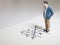 Business and direction concept. Businessman small figure standing on paper and center of circle with more arrows point to many di