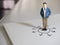 Business and direction concept. Businessman small figure standing on paper and center of circle with more arrows point to many di