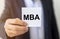 Business education concept. text MBA acronym on white paper note in businessman hand. magic of education