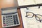 Business and finance concept of analysis chart, eyeglasses and calculator