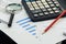 Business financial documents, office calculator and pen on the table. Numbers and graphs