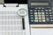 Business financial documents, office calculator and pen on the table. Numbers and graphs