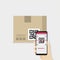 Business hand holding smartphone to scan QR code on box for detail of merchandise.