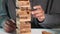 Business hand playing tower wooden blocks game