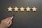 Business hand select five star rating on wooden.