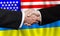 Business handshake on the background of American and Ukrainian flags. Men handshake on the background of the USA and Ukraine flag