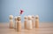 Business and human resources concept for leadership and team leader. A red pin pinned on one wooden doll stands apart and stands