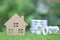 Business investment and real estate, Model house with banknote on natural green background, Saving for prepare in future