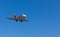 Business jet airplane flying on a high altitude above the blue cloudless sky.