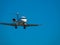 Business jet airplane flying on a high altitude above the blue cloudless sky.