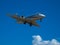 Business jet airplane flying on a high altitude above the blue cloudless sky.