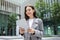 business lady happily browsing on digital tablet computer, standing outside