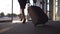 Business lady leaving airport through automatic glass door with her luggage. Young woman in heels walking from terminal