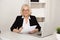 Business lady in office holding paper documents and smiling.