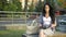 Business lady sitting on a bench pulls her notebook out of the bag to write a reminder. Young woman writes a pen in a