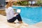 Business lady working on computer by the pool