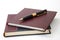 Business leather agendas in a pile with a golden pen