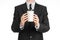 Business lunches coffee theme: businessman in a black suit holding a white blank paper cup of coffee with a brown plastic cap isol