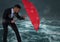 Business man behind umbrella against stormy sea with bokeh